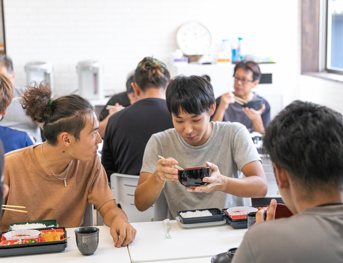 社員同士が笑顔でランチを囲み仲間との親睦を深めながらリフレッシュするクラタの明るい休憩風景